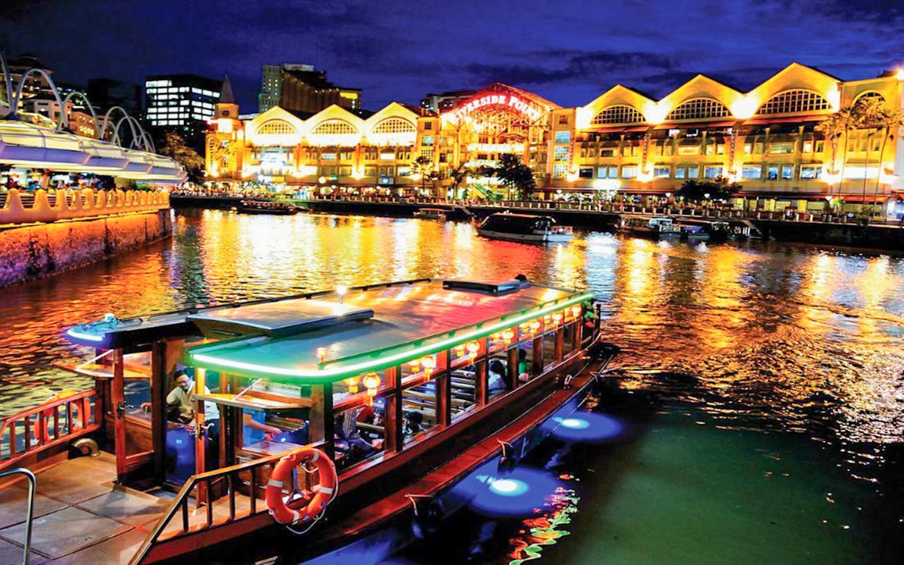 Boat on Singapore River with colorful lights, Riverside Point in the background, FunVee WOW Night Tour.