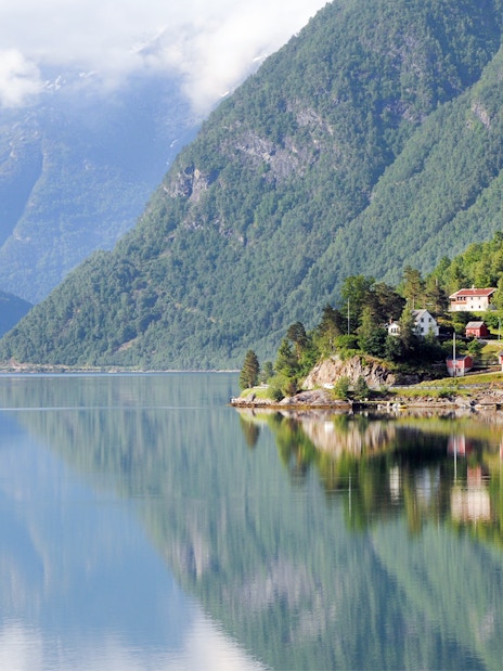 Small villages and mountains along a fjord viewed from a ferry.