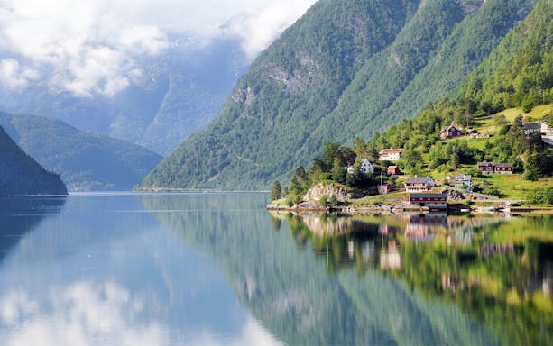 Small villages and mountains along a fjord viewed from a ferry.