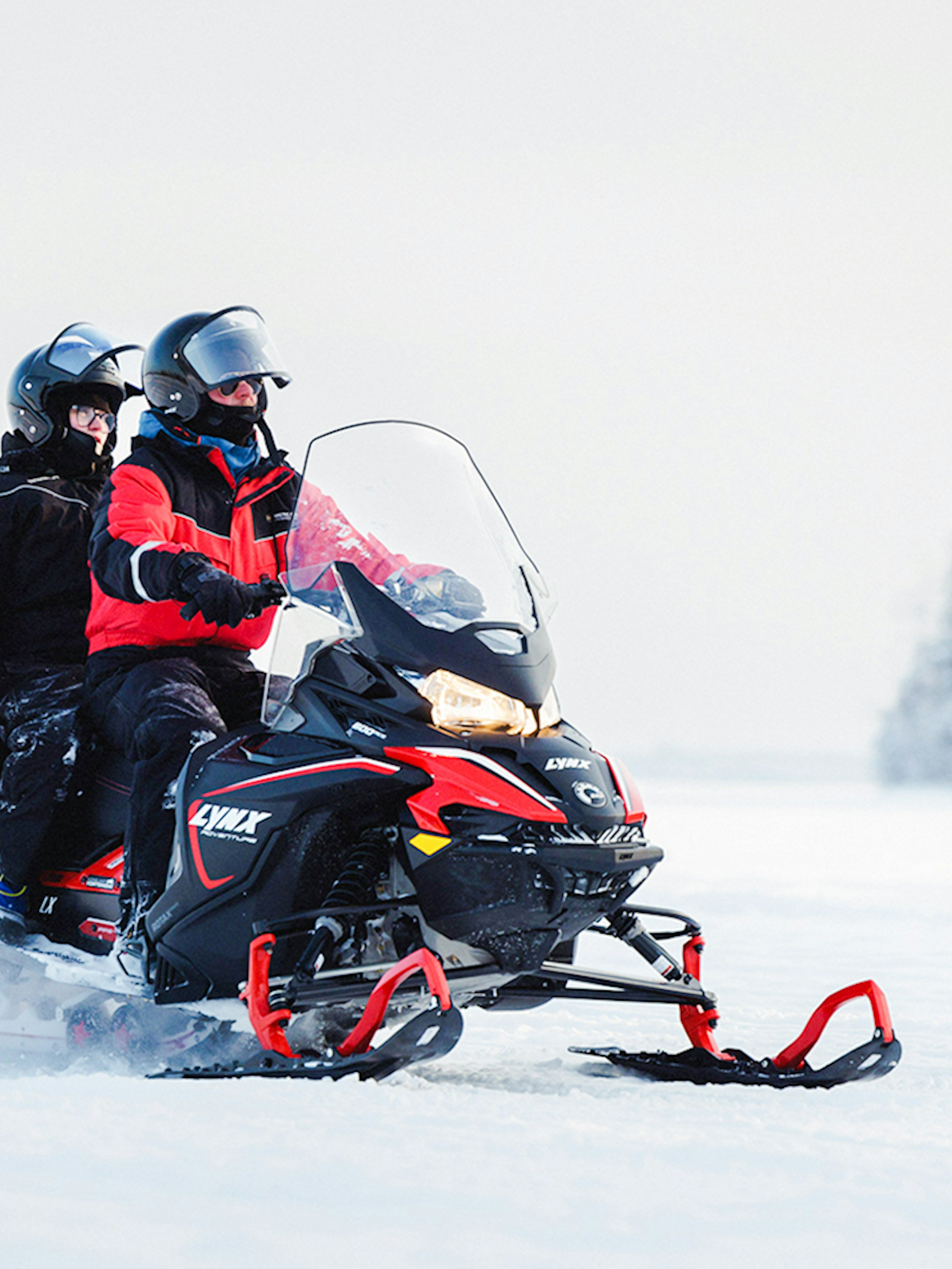 Snowmobile safari in snowy Lapland landscape.