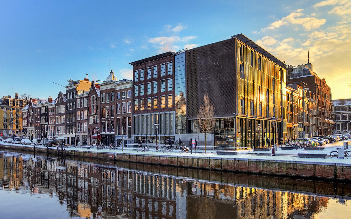 Anne Frank House and canal view in Amsterdam at sunset.