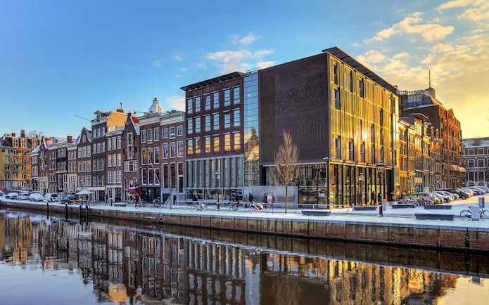 Anne Frank House and canal view in Amsterdam at sunset.