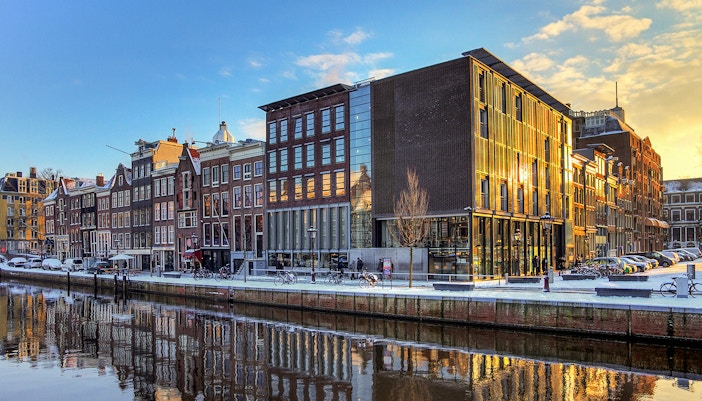Anne Frank House and canal view in Amsterdam at sunset.