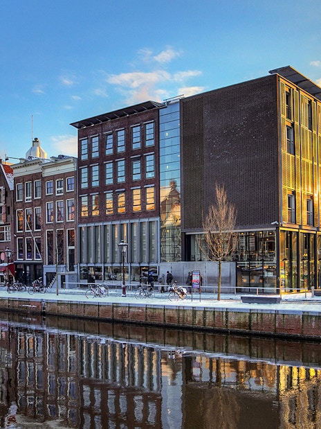 Anne Frank House and canal view in Amsterdam at sunset.