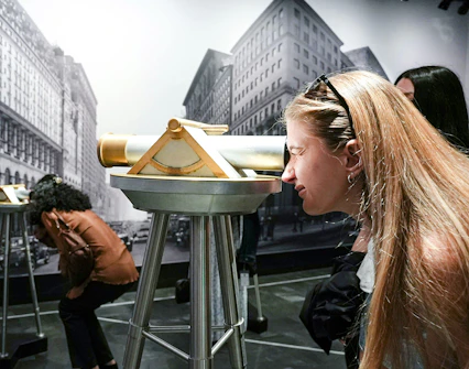 Visitors using telescopes at Empire State Building exhibit in New York City.