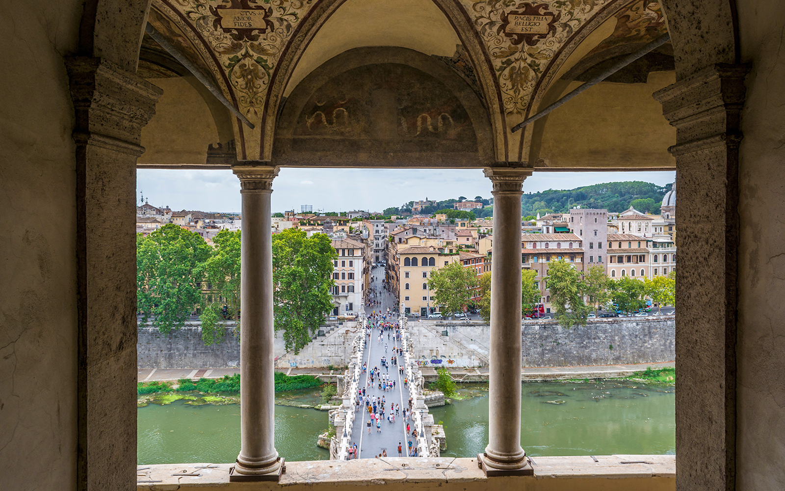 View from Castel Sant'Angelo of people walking on St. Angel Bridge, Rome.