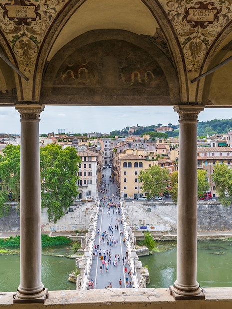 View from Castel Sant'Angelo of people walking on St. Angel Bridge, Rome.