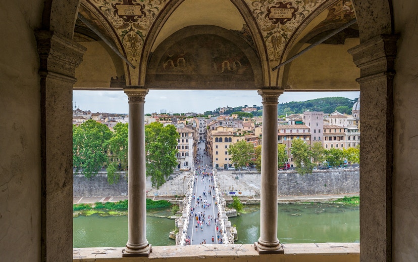 View from Castel Sant'Angelo of people walking on St. Angel Bridge, Rome.