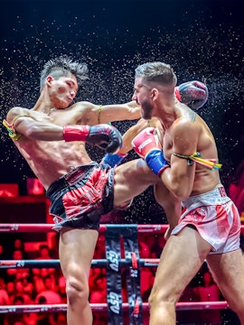 Muay Thai fighters in action at a boxing ring in Thailand.