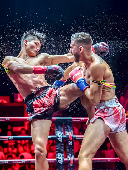 Muay Thai fighters in action at a boxing ring in Thailand.