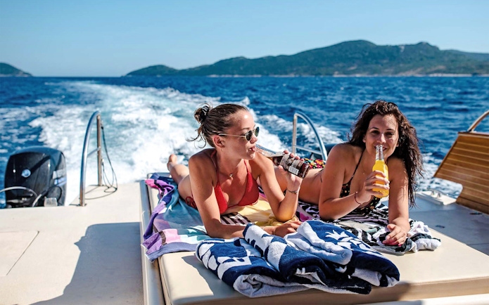 Boat ride with friends enjoying drinks, Dubrovnik, Croatia.