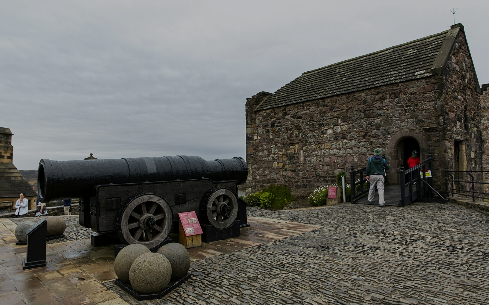 Mons Meg cannon at Edinburgh Castle with visitors nearby.