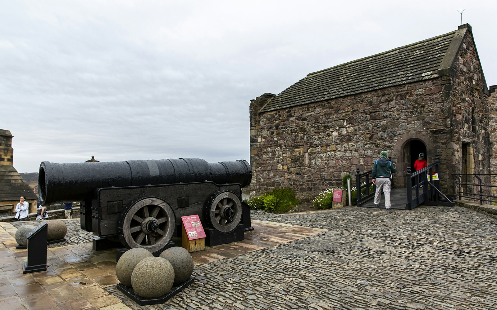 Mons Meg cannon at Edinburgh Castle with visitors nearby.