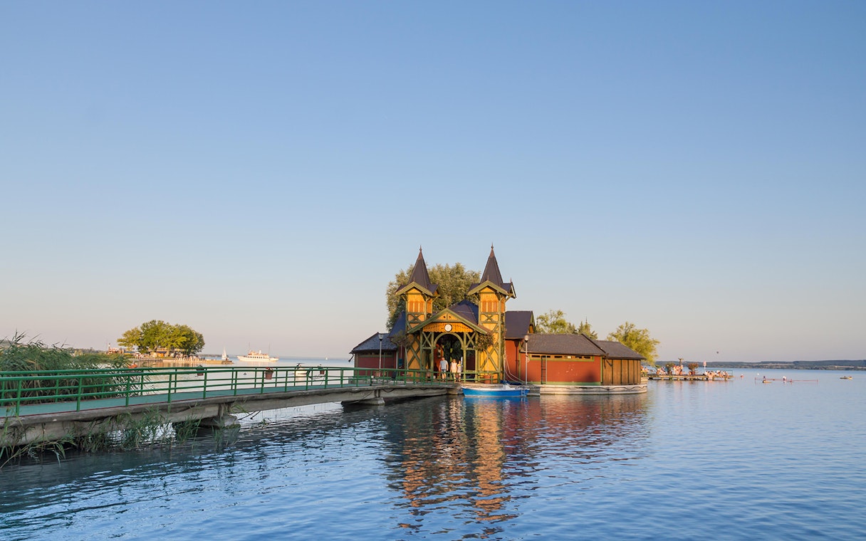 Lake Balaton pier with historic building and cruise ship in the distance, Hungary.