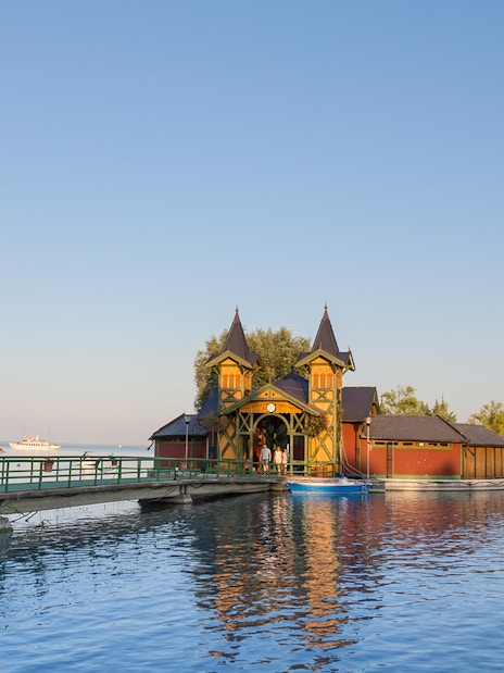 Lake Balaton pier with historic building and cruise ship in the distance, Hungary.