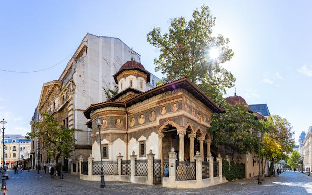 Stavropoleos Monastery Church in Bucharest with ornate frescoes and cobblestone street.