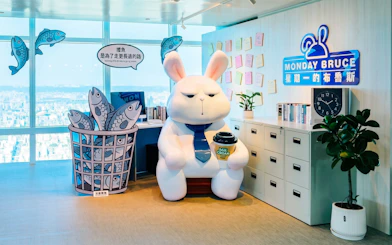 Cartoon rabbit statue with coffee cup at Taipei 101 Observatory office display.