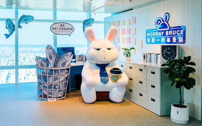 Cartoon rabbit statue with coffee cup at Taipei 101 Observatory office display.