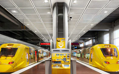 Stockholm Arlanda Express trains at underground station platform with ticket machine.