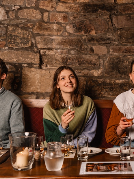 Guests enjoying whisky tasting at an underground tour in Edinburgh.