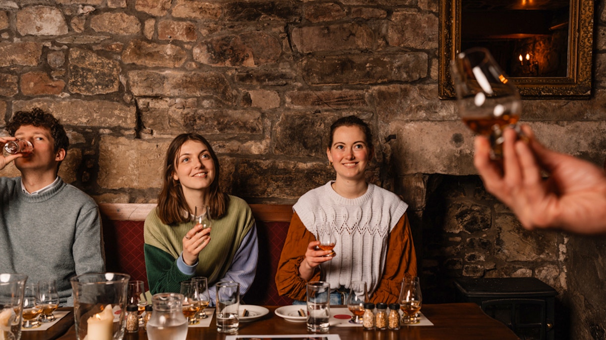 Guests enjoying whisky tasting at an underground tour in Edinburgh.