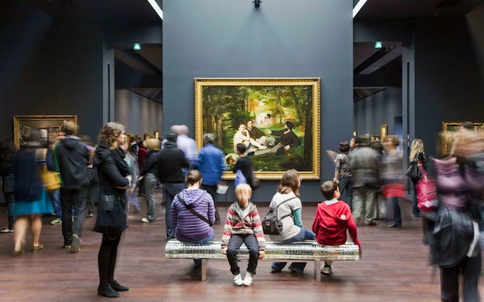 Visitors viewing art at Musée d’Orsay during a guided tour.