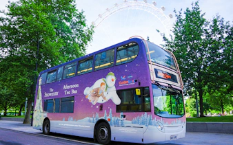 Double-decker bus with "The Snowman Afternoon Tea" design near the London Eye.