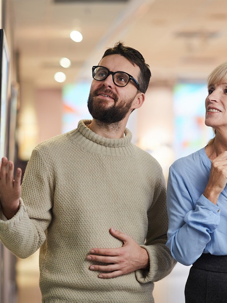 Visitors admiring artwork in a museum gallery.