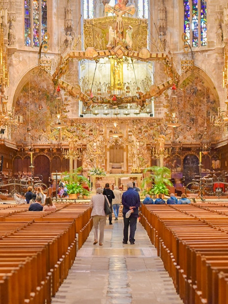 Palma Cathedral interior with ornate altar and stained glass windows.