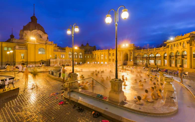 Szechenyi Thermal Bath evening view with visitors in Budapest, Hungary.