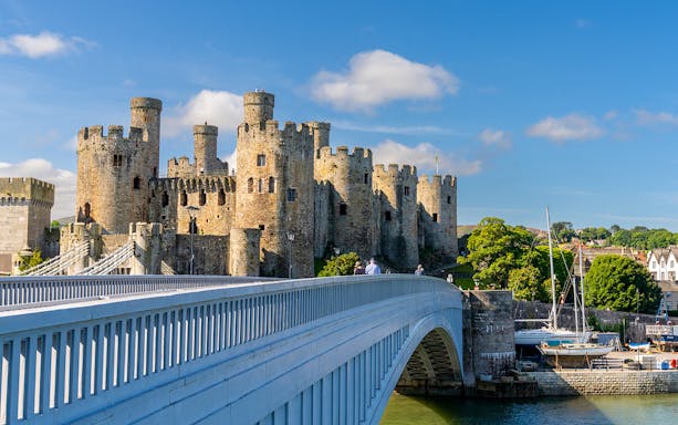 Conwy Castle with a bridge in Llandudno, part of the Hop-On Hop-Off Tour.