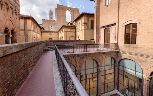 Palazzo delle Papesse courtyard with view of Siena Cathedral tower, Italy.