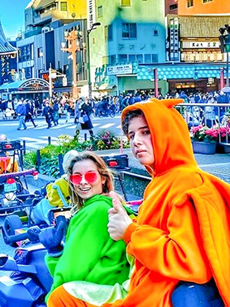 People in costume driving go-karts near Senso-ji Temple, Tokyo.