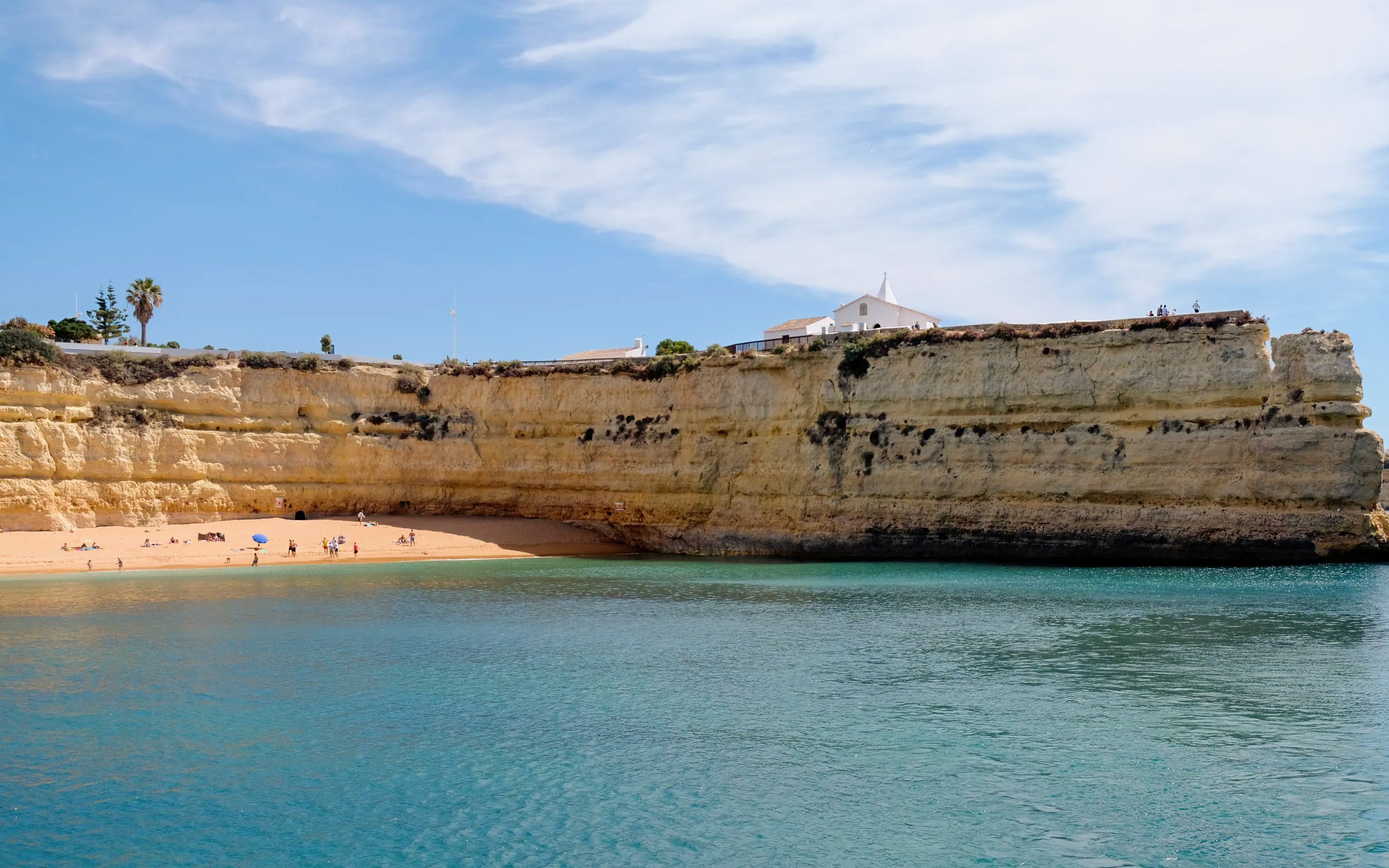 Benagil Caves coastline with sandy beach and cliffs in Algarve, Portugal.