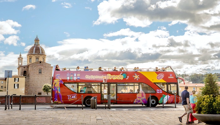 Tourists enjoying the 24 Hour Hop-On Hop-Off Tour in Florence, Italy with a view of the Florence Cathedral in the background