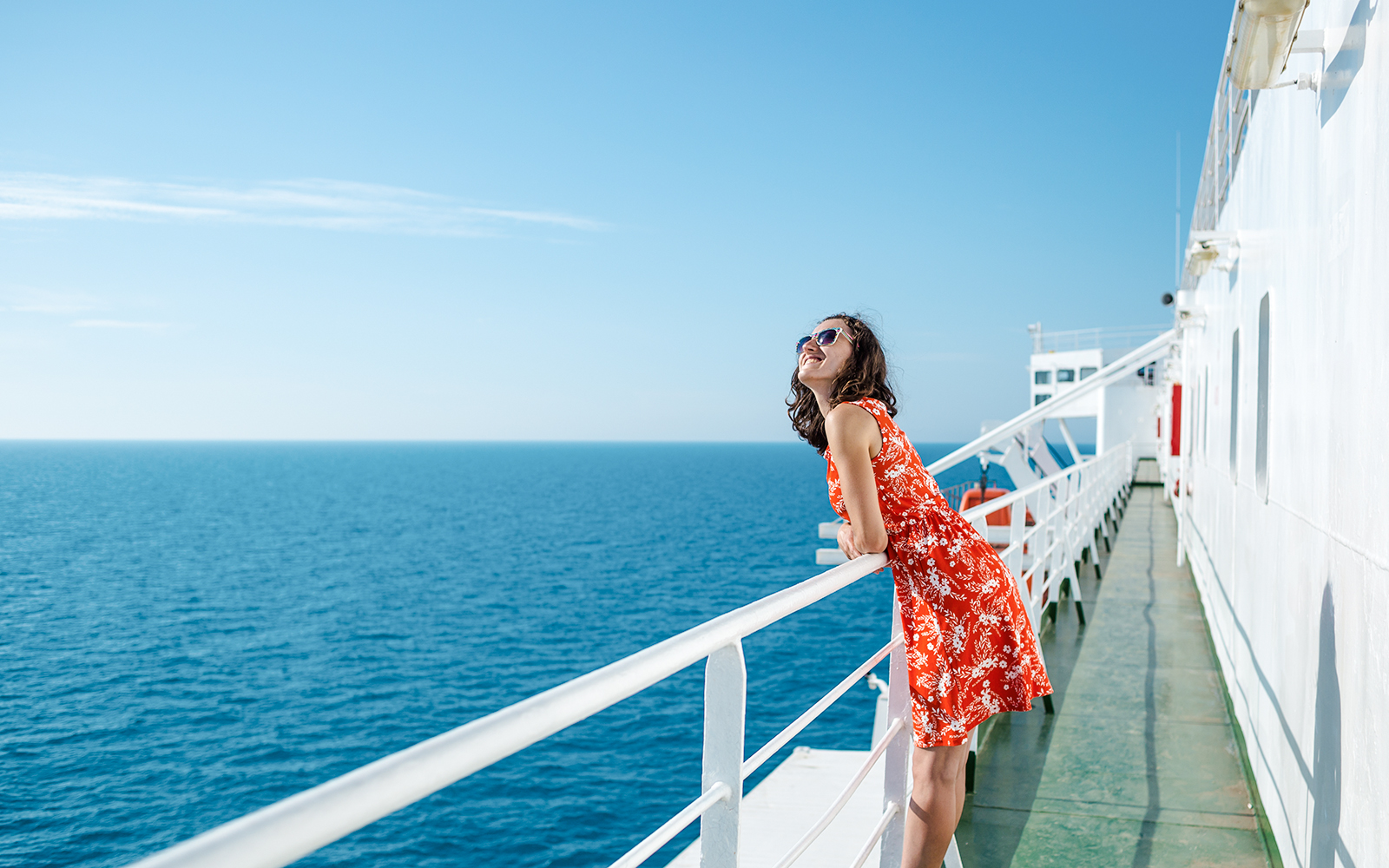 Woman enjoying ocean view from cruise ship deck.