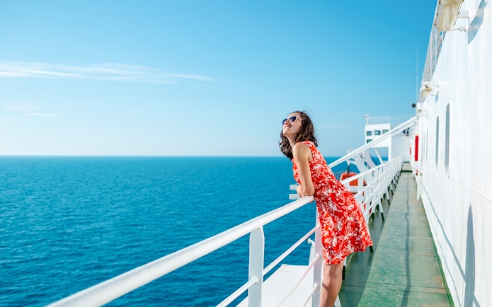 Woman enjoying ocean view from cruise ship deck.