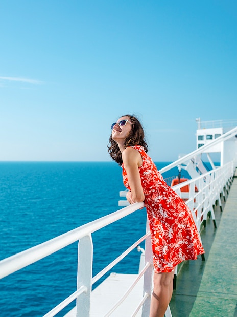 Woman enjoying ocean view from cruise ship deck.