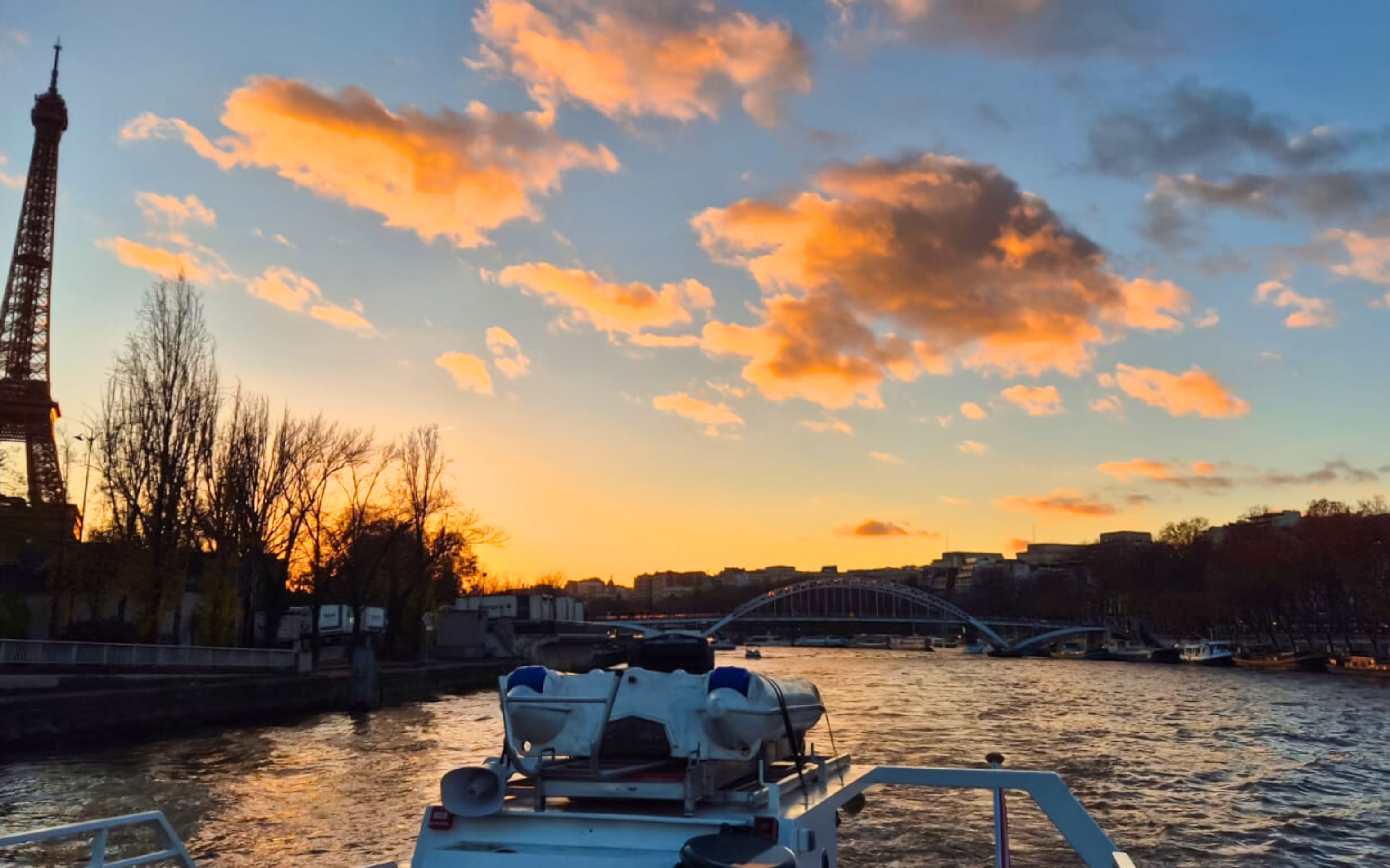 Seine River cruise at sunset with Eiffel Tower and bridge in Paris, France.