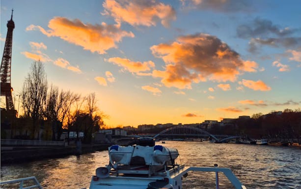 Seine River cruise at sunset with Eiffel Tower and bridge in Paris, France.