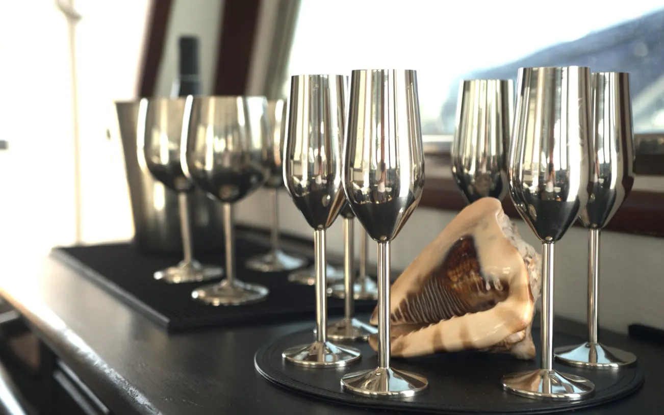 Silver wine glasses and a conch shell on a table during Benalmádena Solar Eclipse Dinner Cruise.