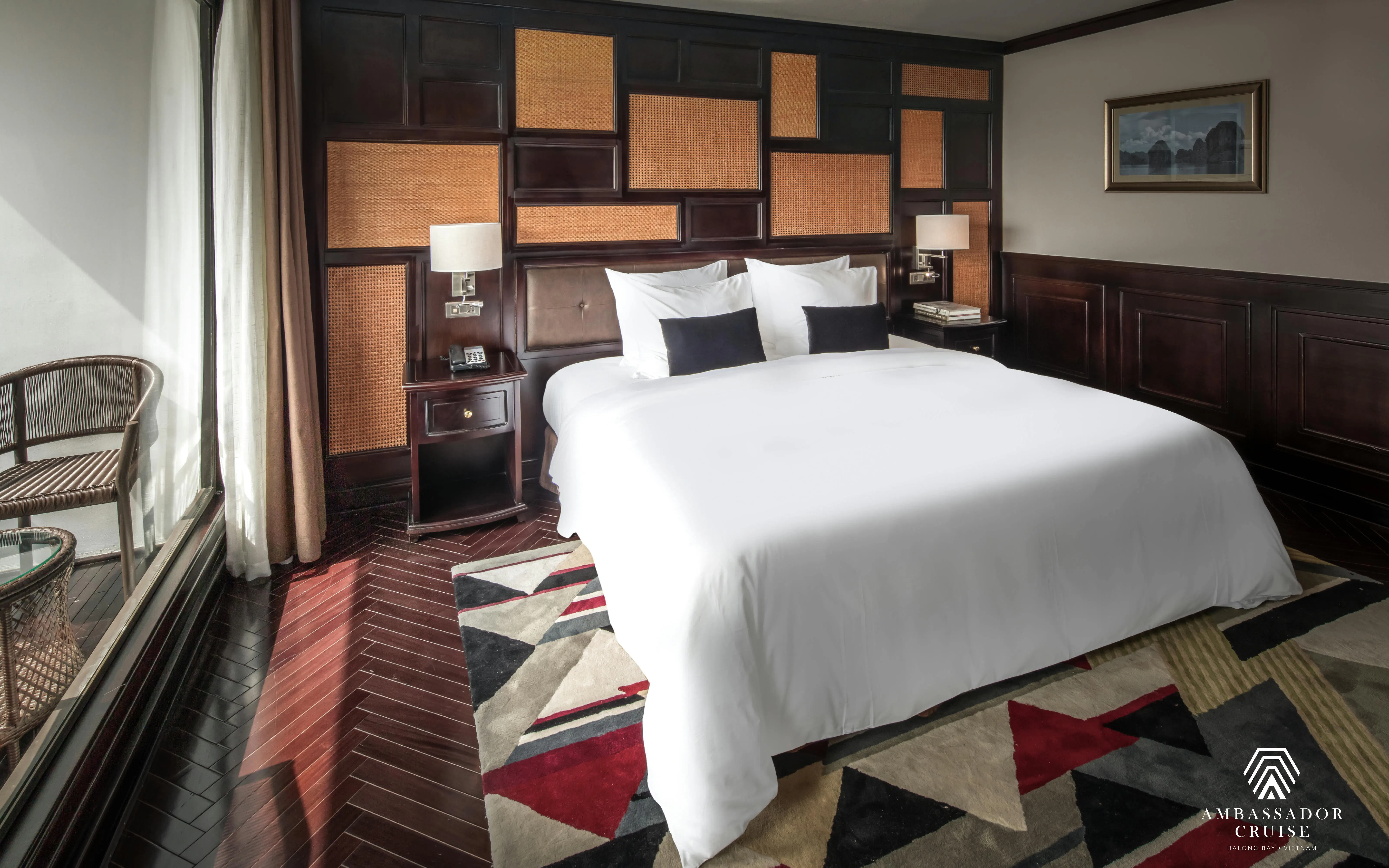 Luxurious bedroom on Ambassador Premium cruise with elegant decor and large window view.