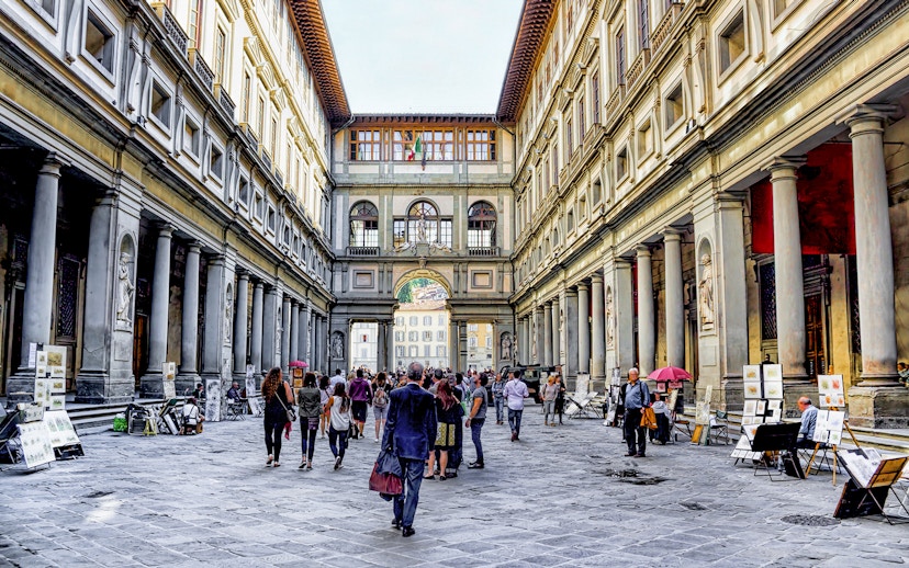 Visitors walking through the arcade of the Uffizi Gallery in Florence, Italy.