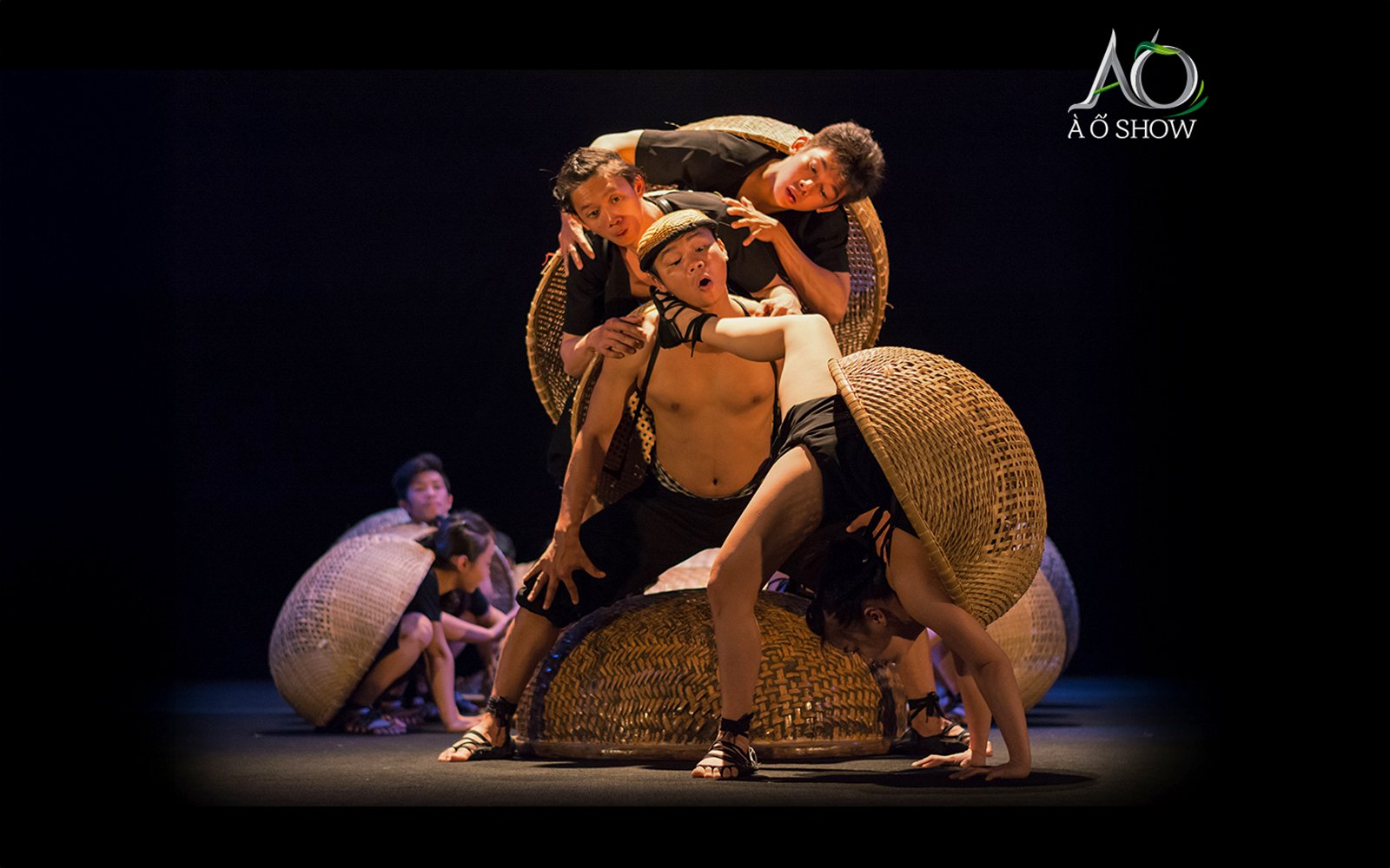 Performers balancing on woven baskets during traditional AO show.