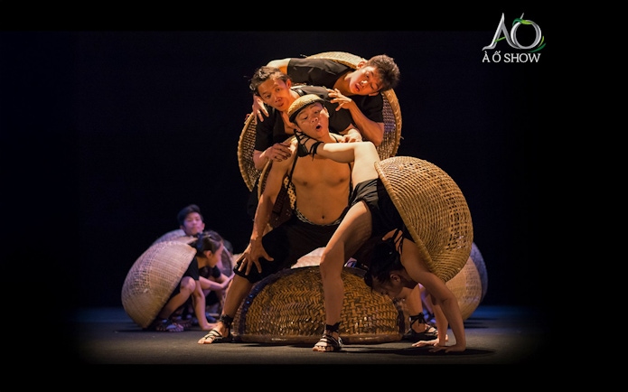 Performers balancing on woven baskets during traditional AO show.