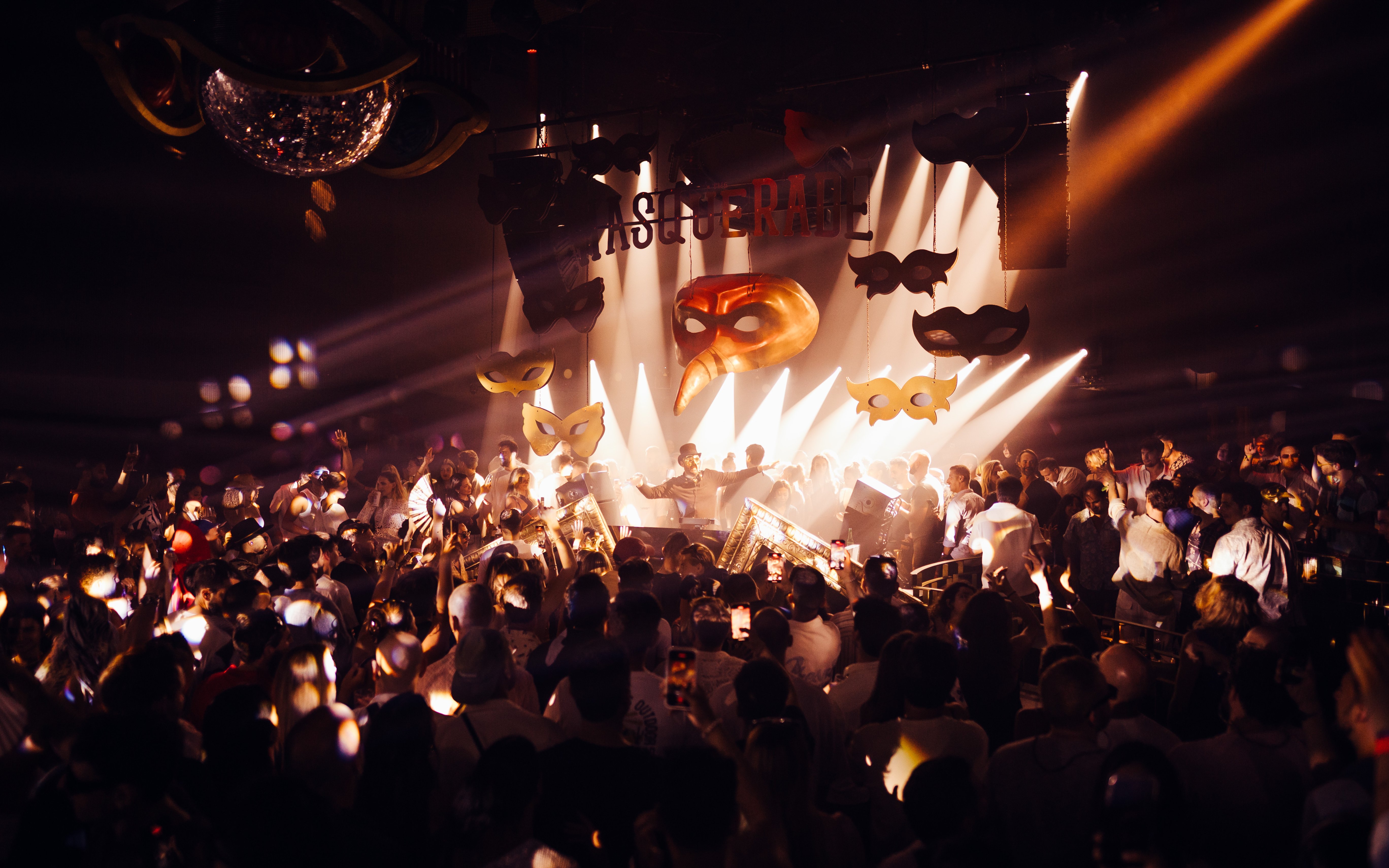 DJ performing at The Masquerade by Claptone, Ibiza with crowd and masks.
