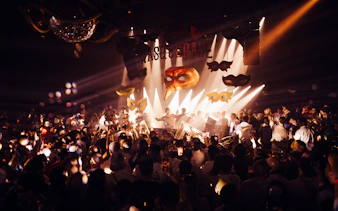 DJ performing at The Masquerade by Claptone, Ibiza with crowd and masks.