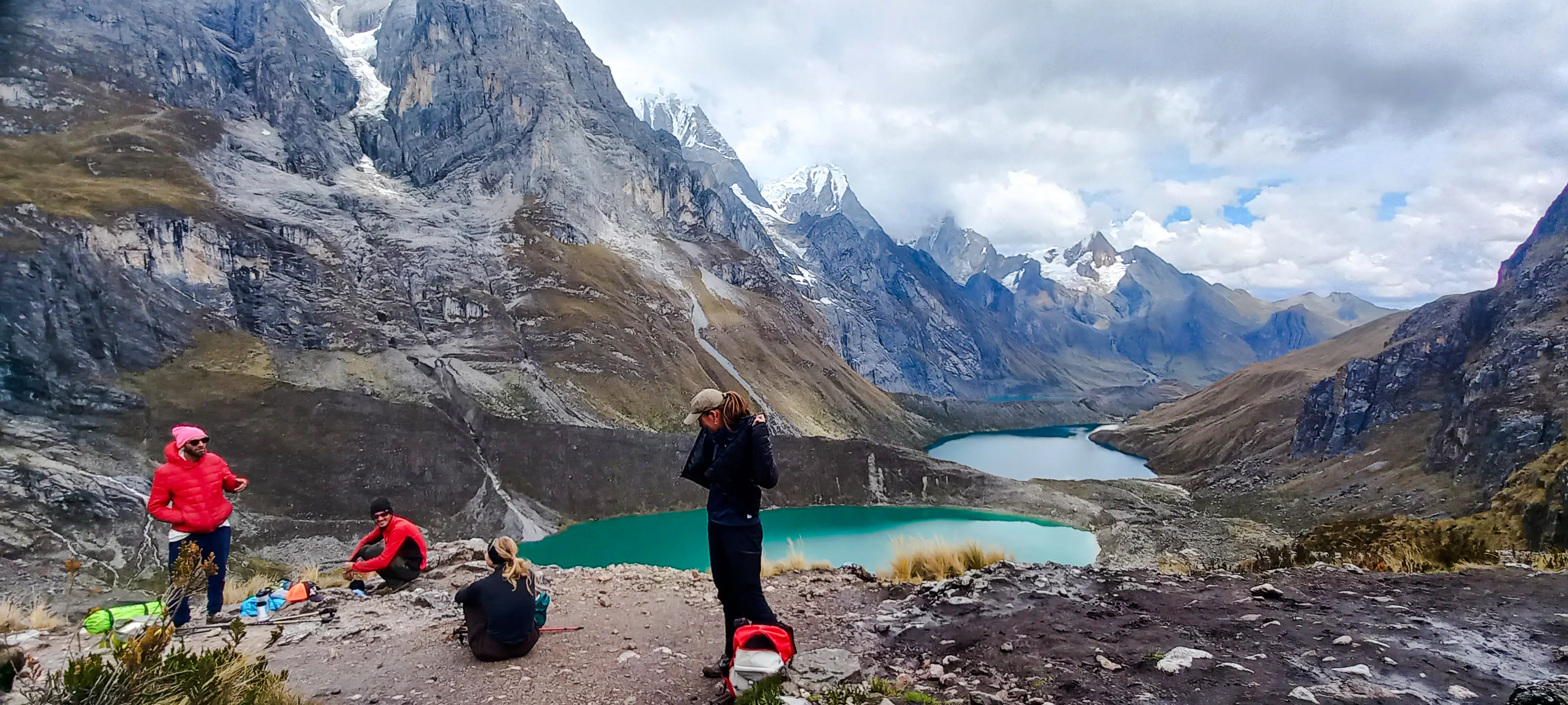 Hikers overlooking turquoise lakes and snow-capped peaks on the Huayhuash Trek, Peru.