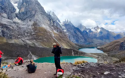 Hikers overlooking turquoise lakes and snow-capped peaks on the Huayhuash Trek, Peru.