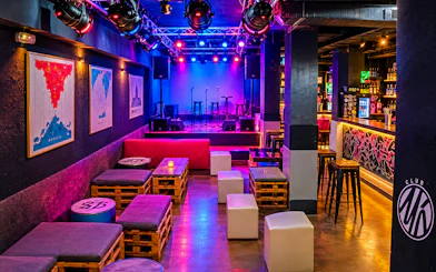 Nightclub interior with colorful lights, stage, and seating in Tangier.